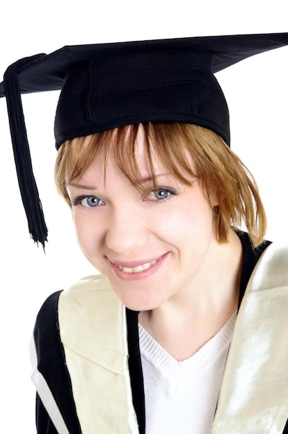 A college graduate in cap and gown, looking relieved and smiling, with a 