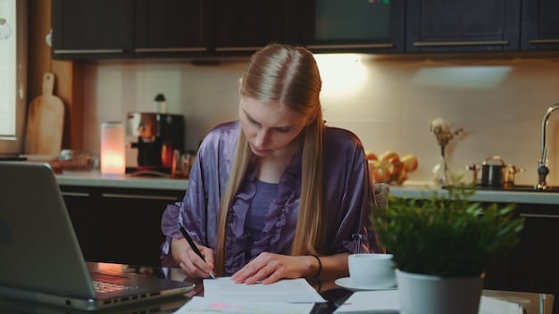 A person reviewing a student loan forgiveness application form on their laptop, with a pen in hand and a focused expression, in a brightly lit home office setting.