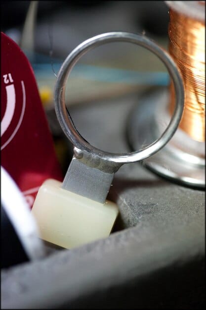 A close-up image of a Shein clothing tag with a magnifying glass over it, symbolizing the investigation into the materials and manufacturing processes.